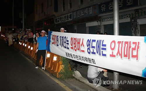 ▲ (부산=연합뉴스) 김선호 기자 = 30일 오후 전국에서 모인 '3차 희망버스' 참가자들이 부산역 광장에 모여 문화제를 가진 뒤 김진숙 민주노총 지도위원이 고공 농성을 벌이고 있는 한진중공업으로 가는 길인 영도다리 입구에 영도구민들이 희망버스를 반대하는 내용의 플래카드를 내걸고 있다ⓒ