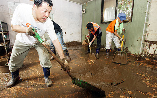 ▲ 29일 경기도청 공무원들이 대쌍령리 한 식당에서 수해복구 자원봉사활동을 벌이고 있다. 경안천 상류에 있는 이 식당은 27일 내린 폭우로 하천이 범람해 3m 가까이 물에 잠겼다. 물이 빠져 나간 자리는 진흙 밭이 됐다 . ⓒ 뉴데일리