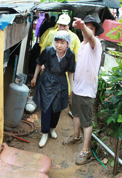 ▲ 한나라당 박근혜 전 대표가 31일 비를 맞으며 최근 집중호우로 큰 피해를 본 서울시 서초구 남태령 전원마을을 둘러보고 있다. ⓒ 이정현 의원실 제공