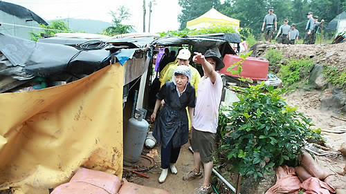 ▲ 한나라당 박근혜 전 대표가 31일 비를 맞으며 최근 집중호우로 큰 피해를 본 서울시 서초구 남태령 전원마을을 둘러보고 있다. ⓒ연합뉴스