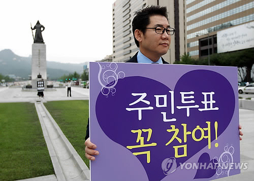 ▲ 방송인 박상원씨가 19일 오전 광화문광장에서 무상급식 주민투표 참여를 독려하는 피켓을 들고 있다.ⓒ연합뉴스