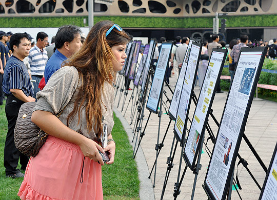 ▲ 문화제에 앞서 주최측이 서울광장에 전시한 북한 인권법 관련 자료와 사진들을 외국인이 유심히 살펴보는 모습.ⓒ 뉴데일리 추진혁 기자