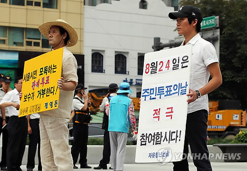 ▲ 무상급식 주민투표를 이틀 앞둔 22일 오후 서울 광화문광장에 엇갈린 입장을 가진 시민 두 명이 함께 1인 피켓 캠페인을 벌이고 있다. ⓒ연합뉴스