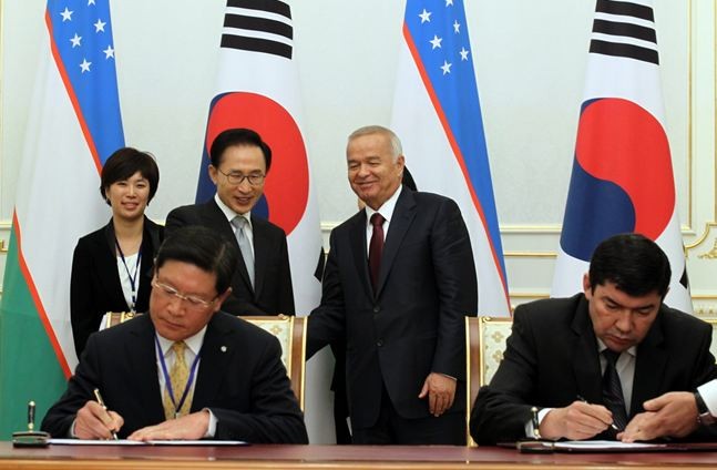 ▲ 23일(현지시간) 이명박 대통령과 이슬람 카리모프 우즈베키스탄 대통령이 지켜보는 가운데 한-우즈벡 관계자가 협정문에 서명하고 있다.ⓒ청와대