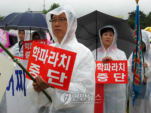 ▲ 2009년 7월 24일 경남 창원 용지공원에서 열린 경남도 학원인 총궐기대회에서 학원 운영자들이 우산을 쓴 채 `학파라치 중단' 피켓을 들고 있다. ⓒ연합뉴스