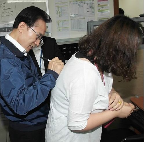 ▲ 이명박 대통령이 2일 오전 경기도 수원시 장안구 윌테크놀러지사를 방문, 사인을 요청하며 등을 내미는 여직원 등판에 사인하고 있다. ⓒ연합뉴스