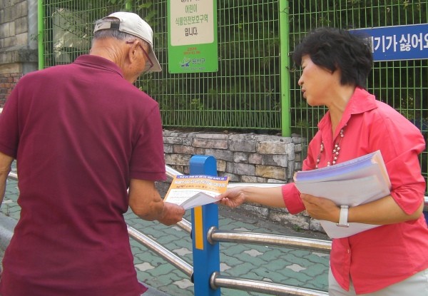 ▲ 사진 = 공학연 이경자 상임대표가 백 교수의 실상을 알리는 4,000여 부의 홍보 전단지를 시민들에게 나눠주고 있다.