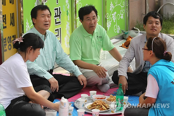 ▲ '지금 술이 넘어 갑니까?' 12일 오후 한진중공업을 찾아 크레인을 불법점거 중인 김진숙 지도위원을 전화통화로 격려한 손학규 대표가 해고자 가족과 막걸리를 마시고 있다.ⓒ연합뉴스