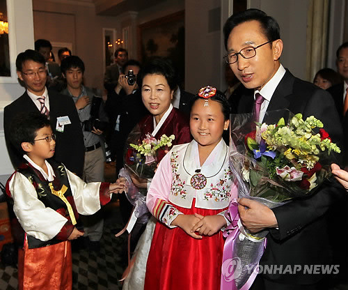 ▲ 이명박 대통령과 부인 김윤옥 여사가 22일(한국시간) 미국 뉴욕 피에르 호텔에서 열린 동포간담회에서 어린이들에게서 꽃다발을 받고 있다.ⓒ연합뉴스