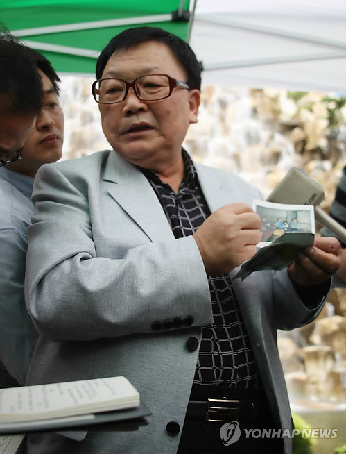 ▲ 사진 = 22일 오후 경남 창원시 마산대학에서 열린 '신숙자씨 구출 서명운동' 현장을 방문한 신씨 남편 오길남 박사가 신숙자씨와 딸 혜원, 규원이 찍힌 사진을 취재진에게 보여주고 있다.