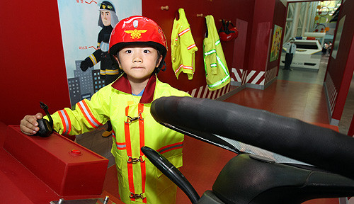 ▲ 한 어린이가 늠름한 소방관으로 변신했다. 지하 1층부터 지상 3층까지 구성된 10개의 전시실에서는 스포츠, 과학탐구, 인체탐구, 환경, 다문화생활체험 등 어린이들의 자발적인 체험과 학습이 가능하다.ⓒ뉴데일리