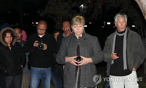 ▲ 잡스 추모하는 캐시 코비씨(쿠퍼티노<美캘리포니아>=연합뉴스) 임상수 특파원 = 스티브 잡스의 사망소식 발표 후 4시간이 지난 5일 오후 8시30분께(현지시간) 미국 캘리포니아주 쿠퍼니노시에 위치한 애플 본사 사옥을 둘러싼 인피니트 루프 한쪽 벤치에 마련된 영정 앞에서 캐시 코비씨(오른쪽 두번째)가 아이폰을 꺼내 촛불영상을 올려 놓고서 다른 추모객들과 잡스를 추모하고 있다. ⓒ