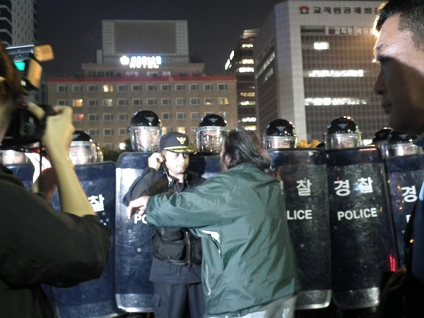 ▲ 부산시민단체 회원들에게 얻어맞다 경찰에 구출된 사람이 경찰에게 '왜 맞는데 말리지 않았냐'며 항의하고 있다.