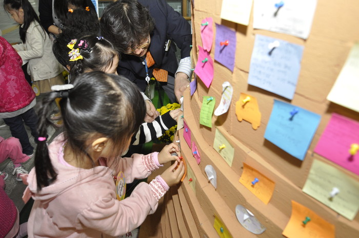 ▲ 11일 서울 매봉역에 설치된 희망탑에 한 어린이가 자신의 소원을 적은 쪽지를 붙이고 있다.ⓒ뉴데일리