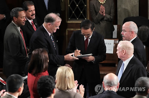 ▲ 이명박 대통령이 13일(현지시간) 워싱턴 DC 미 하원 본회의장에서 연설을 마친 뒤 미 의원들이 건넨 연설문에 사인해 주고 있다.ⓒ