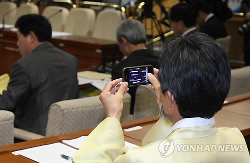 ▲ 민노당 강기갑 의원이 20일 국회 외교통상통일위원회의 한-미 자유무역협정(FTA) 끝장 토론회에 서 스마트폰으로 기록하고 있다. ⓒ연합뉴스