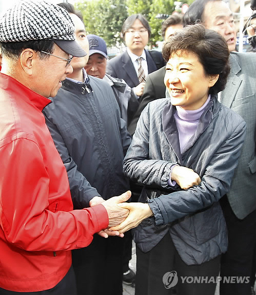 ▲ 박근혜 전 한나라당 대표가 22일 충남 서산을 찾아 부은 오른 손 대신 왼손으로 악수하며 지원을 호소하고 있다.ⓒ연합뉴스