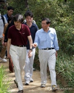 ▲ 무소속 박원순 후보의 온천관광 효도 발언이 논란을 빚고 있는 가운데 민주당 소속 모 구청장이 노인들을 단풍놀이 보냈다는 의혹이 제기됐다. 사진은 박 후보와 조 교수가 등산을 하면서 대화를 나누는 장면.  ⓒ 연합뉴스