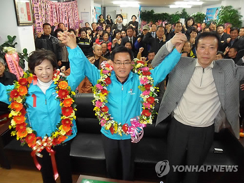 ▲ 26일 경북 칠곡군수 재선거에서 당선된 한나라당 백선기(앞줄 가운데) 후보가 지지자들과 함께 손을 들고 기뻐하고 있다. ⓒ 연합뉴스
