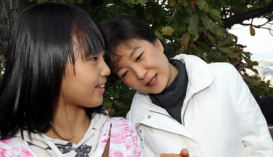 ▲ 박근혜 전 대표가 지난 23일 서울 남산에서 한 어린이와 사진을 촬영한 뒤 내용을 확인하고 있다.   ⓒ 연합뉴스