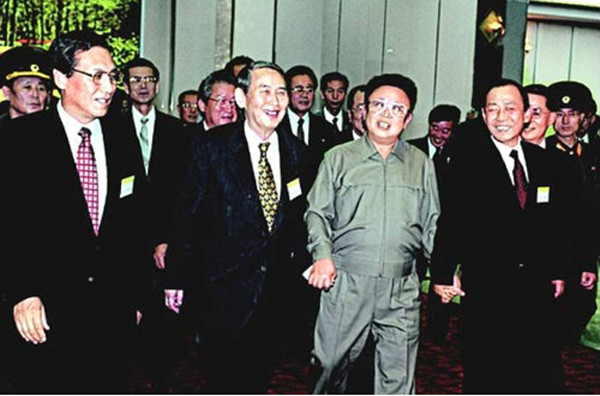 ▲ 2000년 8월 남한 언론사 사장단이 평양 목란관에서 기념촬영을 한 뒤 김정일(왼쪽에서 세 번째)과 오찬장으로 가고 있는 모습. 김정일은 오른 손에 당시 KBS 박권상 사장, 왼손에 당시 최학래 한겨레신문 사장의 손을 잡고 있다/동아일보 자료사진 ⓒ