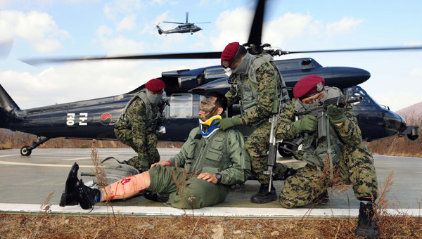 ▲ 공군 항공구조사들이 가상 적지에 조난된 조종사에 접근하여 엄호한 상태에서 응급처치를 실시하고 있다.