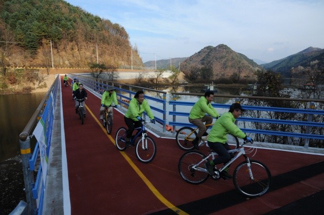 ▲ 북한강 자전거길  개방행사에 참가한 권도엽 국토부 장관(오른쪽 첫 번째)와 심명필 4대강살리기 사업추진본부장(오른쪽 세 번째)이 의암호 덕두원리 자전거길 연결 다리 위를 달리고 있다.  ⓒ 이오봉 기자