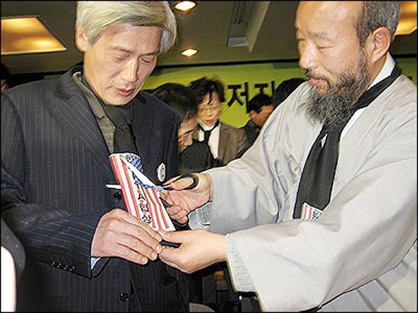 ▲ 2006년 3월 28일 FTA범국본 출범식을 마친 뒤 '성조기 자르기' 세리머니를 하고 있다.