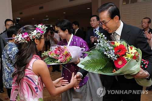 ▲ 하와이 APEC정상회의에 참석하는 이명박 대통령과 부인 김윤옥 여사가 13일 호놀룰루 하얏트 호텔 와이키키에서 열린 동포간담회에서 화동에게 꽃다발을 받고 있다.ⓒ연합뉴스