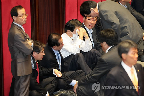 ▲ 국회 본회의에서 한미FTA(자유무역협정)비준안 이 통과된 22일 오후 야당의원들이 발언대에 앉아 허탈해 하고 있다.   한나라당은 이날 민주당과 민주노동당 등 야당 의원들의 강력 저지 속에 비준안을 표결에 부쳐 재적의원 295명중 170명이 참석한 가운데 찬성 151명, 반대 7명, 기권 12명으로 비준안을 통과시켰다.ⓒ연합뉴스