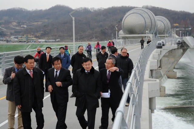 ▲ 이포보 소수력발전소를 둘러보고 나와 일반 방문인들과 함께 공도교를 걸어가면서 수문 권양대, 인공어도 등을 두루 둘러보는 탁신 전 태국 총리(오른쪽에서 두 번째).  왼쪽부터 김철문 4대강살리기 사업지원국장, 심명필 본부장, 이석구 동아일렉트로닉스 회장이 안내를 하고 있다.  ⓒ 이오봉 기자