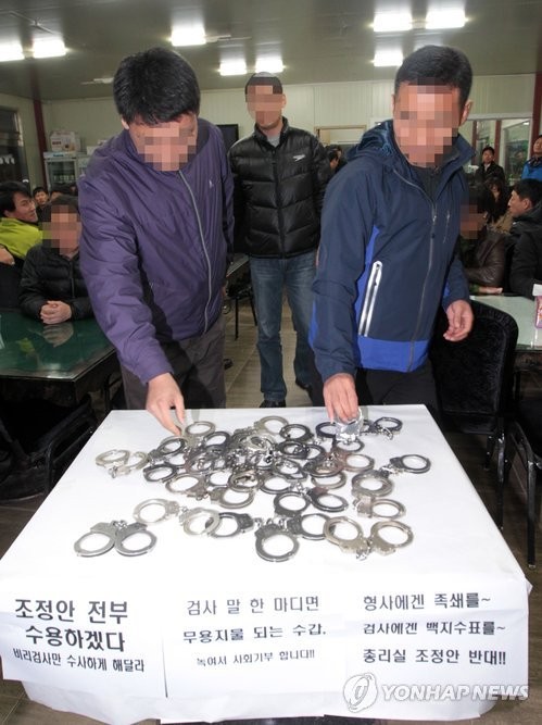 ▲ 전국의일선 경찰들이 국무총리실의 검·경 수사권 조정안에 대한 항의의 표시로 지난 25일 오후 충북 청원군의 한 공원에서 '총리실 조정안의 문제점과 향후 대응방안'을 논의하기에 앞서 경찰들이 수갑을 반납하고 있다 ⓒ 연합뉴스