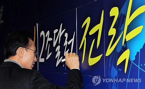 ▲ 이명박 대통령이 15일 서울 서초구 염곡동 코트라에서 열린 2012년 지식경제부.중소기업청 업무보고에서 '1조달러 행정 2조달러 전략' 슬로건에 서명하고 있다. ⓒ 연합뉴스