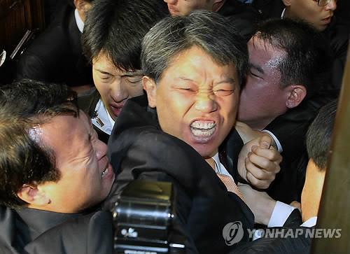 ▲ 지난달 22일 국회 본회의장에서 최루탄 테러를 자행한 민노당 김선동 의원이 경위들에게 끌려나가고 있다. ⓒ연합뉴스