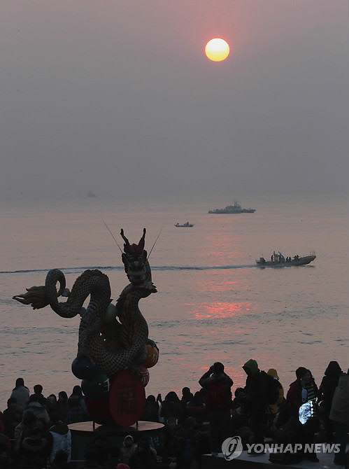 ▲ 1일 우리나라 내륙에서 해가 가장 빨리 뜨는 울산시 울주군 간절곶 해안에 해가 떠올랐다. 해맞이 관광객들이 해안가에 설치된 흑룡 조형물 주변에서 떠오르는 해를 촬영하고 있다.  ⓒ 연합뉴스