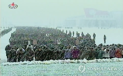▲ 지난해 12월28일 영결식날, 폭설이 내리는 속에 김정일의 영정을 참배하고 있는 북한 주민들의 모습 ⓒ연합뉴스