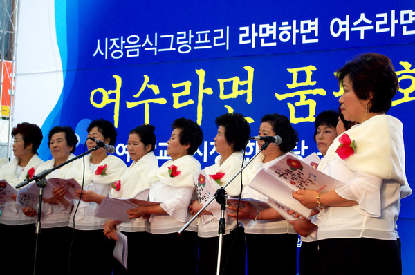 ▲ 동백아가씨 합창단이 축제에서 이미자의 '동백 아가씨'를 부르고 있다.