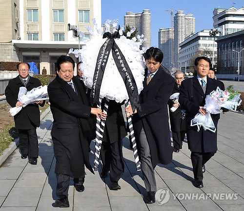 ▲ 문형진 통일교 세계회장(가운데 오른쪽)과 세계평화연합 조의방문단이 김정일 국방위원장 초상화에 화환을 헌화하고 있다고 조선중앙통신이 보도했다. (연합뉴스)