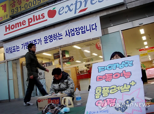 ▲ 지난해 3월 대형 유통업체와 지역 주민 사이에 1년 넘게 갈등이 빚어진 노원구 상계동 홈플러스 익스프레스가 가맹점 모델로 전환해 개점을 강행했다. 개점 첫날인 이날 노원 SSM 입점반대 대책위원회와 주변 상인들이 입점을 반대하며 매장 입구를 지키고 있다. ⓒ연합뉴스