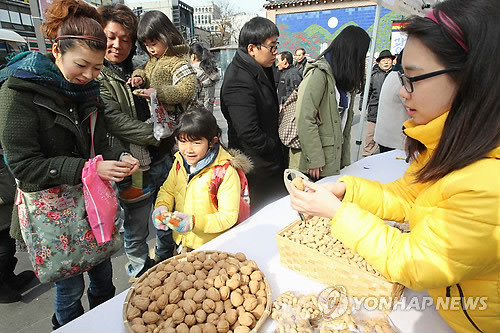 ▲ 일본인 관광객들이 인사동에서 정월대보름 부럼깨기 체험을 하는 모습.ⓒ 사진 연합뉴스