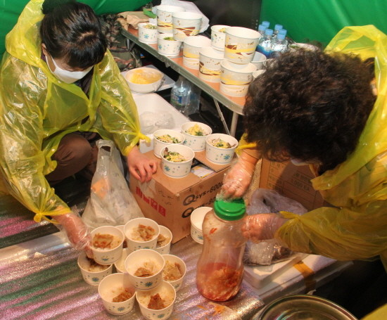 ▲ 북한전통음식문화연구원 회원들이 촛불문화제에 참석한 시민들에 '평양은옥'을 대접하고 있다. ⓒ 뉴데일리