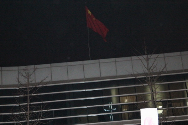 ▲ 7일 오후, 서울 효자동 중국대사관 창문에는 십자가가 비치고 있다. 대사관 건너편에 있는 옥인교회 앞에서는 하루 2번씩 '탈북자 강제북송 중지'를 촉구하는 문화제가 열린다. ⓒ뉴데일리