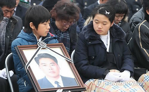 ▲ 지난해 12월14일 불법조업 중국어선 단속 중 순직한 故 이청호 경사의 영결식이 인천해양경찰서 전용부두에서 엄수됐다. 딸 지원양이 영정을 바라보고 있다. ⓒ연합뉴스