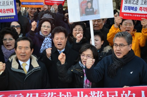 ▲ 정세균(왼쪽) 민주통합당 의원과 박 진(오른쪽) 새누리당 의원이 탈북자들을 사이에 두고 나란히 북송 저지에 관한 구호를 외치고 있다.   ⓒ뉴데일리