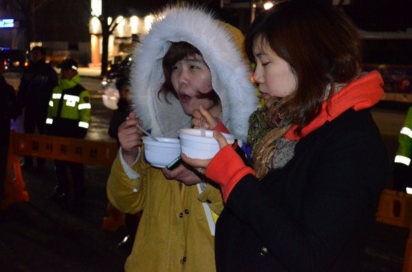 ▲ 탈북자 강제북송 반대 촛불문화제에 참가한 시민들이 평양온반을 먹고있다.