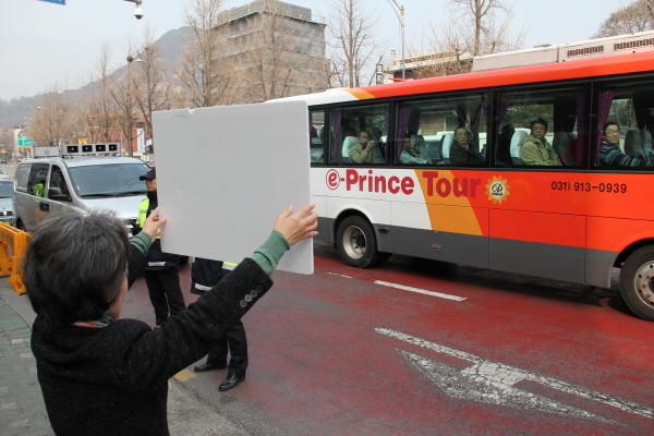 ▲ 자유선진당 박선영 의원이 중국인으로 보이는 관광객들이 버스를 타고 지나가자 '중국의 탈북자 강제북송에 반대한다'는 피켓을 보여주고 있다. ⓒ뉴데일리