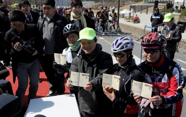 ▲ 한강 능내역 인증센터에서 인증서에 찍은 스탬프를 확인하는 권도엽 국토해양부 장관(연두색 모자)과 참석자들.  ⓒ 이오봉 기자