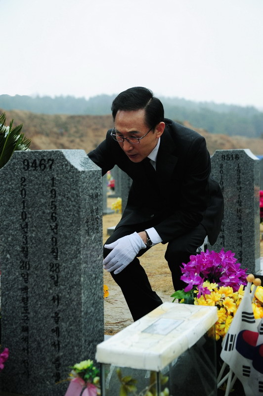 ▲ 이명박 대통령이 23일 천안함 피격 2주기를 맞아 묘역을 참배했다. 이날 이 대통령이 전사자 묘비를 닦으며 안타까워 하는 모습. ⓒ 청와대 제공