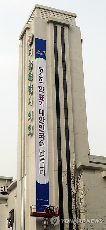 ▲ 22일 서울시선관위가 시의회 외벽에 4.11 총선 투표참여를 호소하는 현수막을 내걸고 있다.ⓒ 사진 연합뉴스