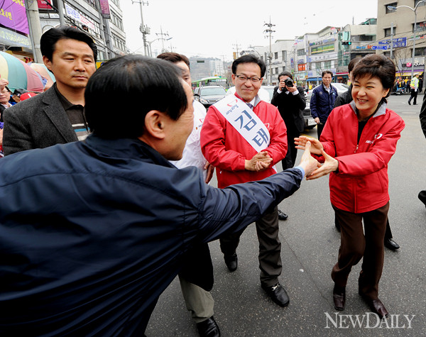 ▲ 박근헤 새누리당 선거대책위원장이 29일 서울 성동갑 김태기 후보의 지지를 호소하며 유권자가 내민 손을 잡고 있다. ⓒ 양호상 기자